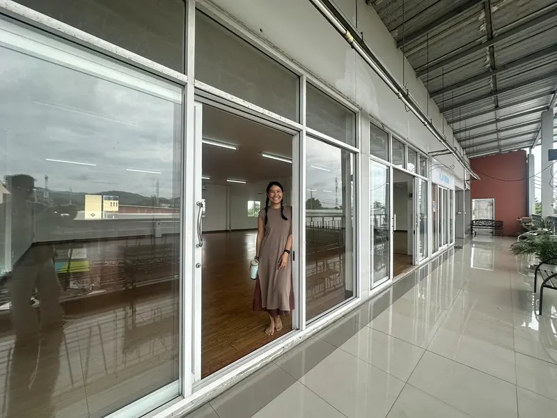 A smiling woman standing in the open sliding door of the studio